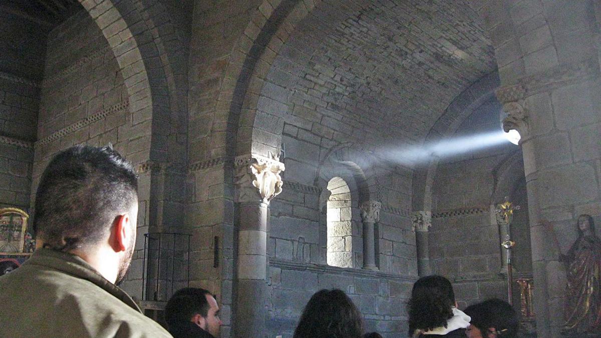 Varias personas contemplan la luz equinoccial en el monasterio de Santa Marta de Tera.