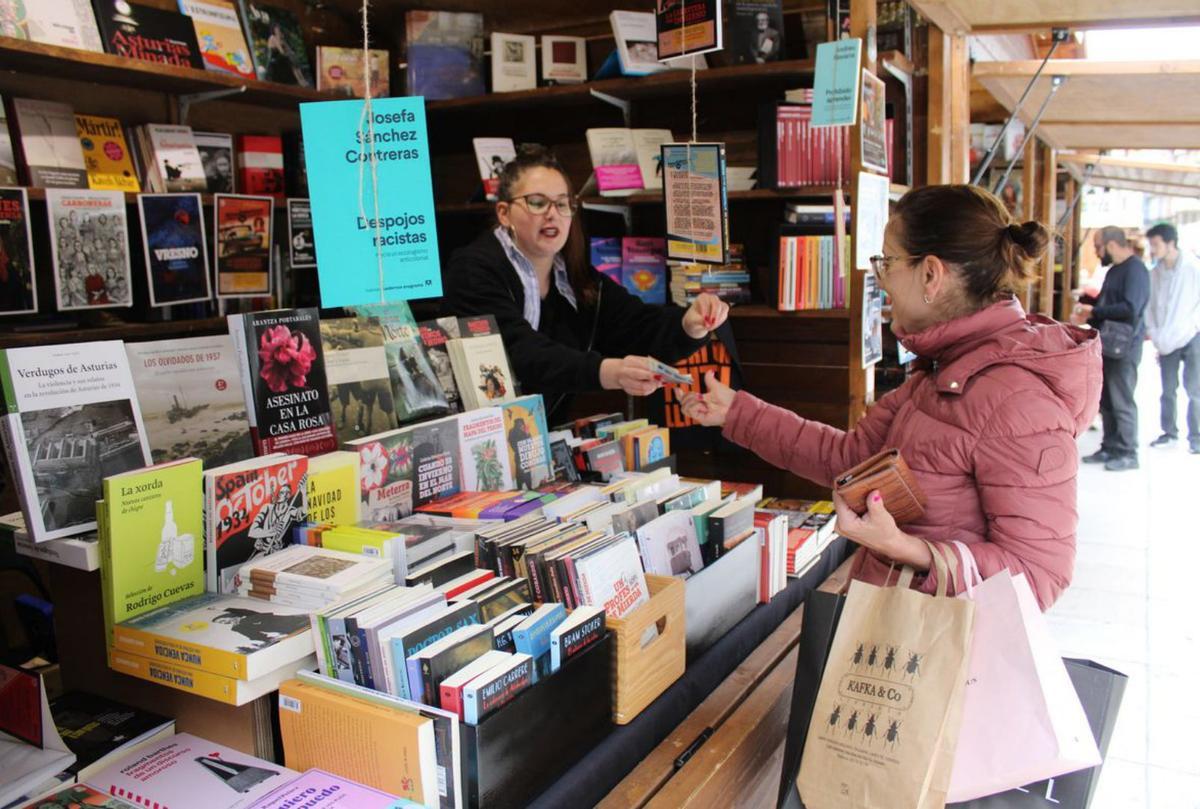 María Jesús Domínguez comprando libros a Natalia González en el puesto de Matadero Uno. | JER OSPINA