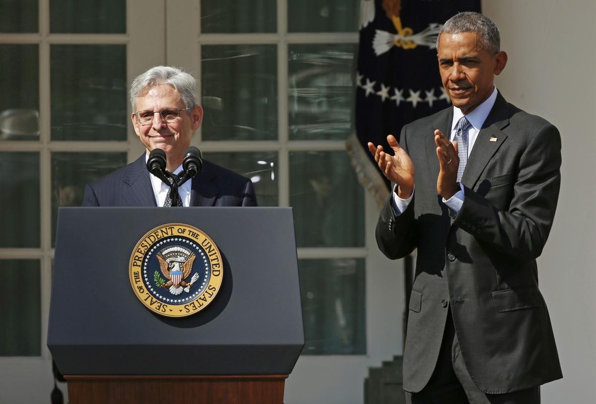 Judge Merrick Garland speaks at the podium as U.S. President Barack Obama applauds after Obama announced him as his nominee to the U.S. Supreme Court, in the Rose Garden of the White House in Washington D.C., March 16, 2016.  REUTERS/Kevin Lamarque