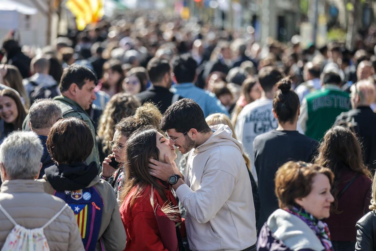 Una pareja se besa en el paseo de Gràcia, durante la jornada de Sant Jordi