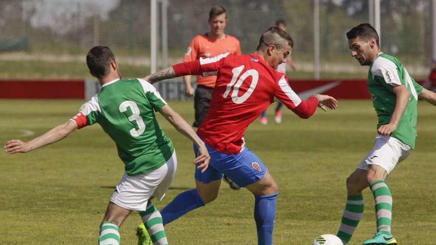 El sportinguista Isma Cerro regatea a dos futbolistas del Llanes.