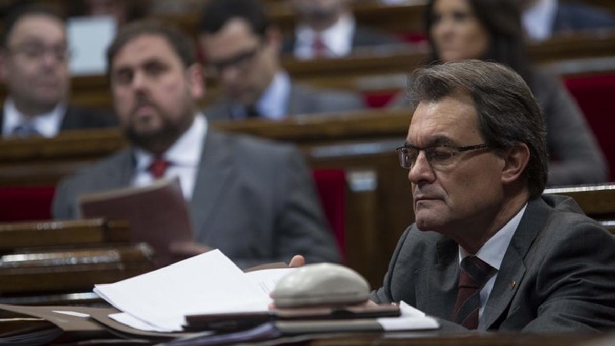 Artur Mas, en primer término, y Oriol Junqueras, detrás, en el Parlament.