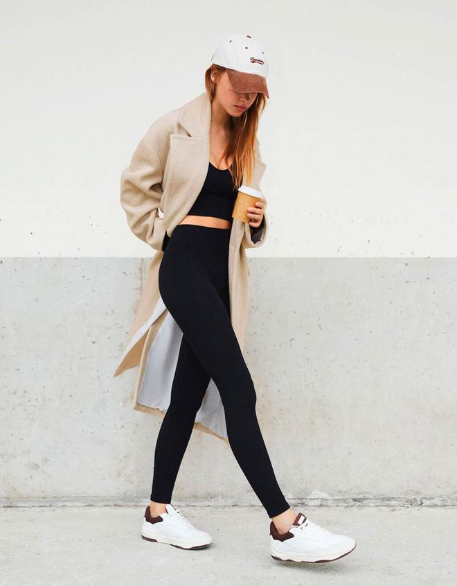 El look de Bershka con top y leggings combinado con abrigo, gorra y zapatillas