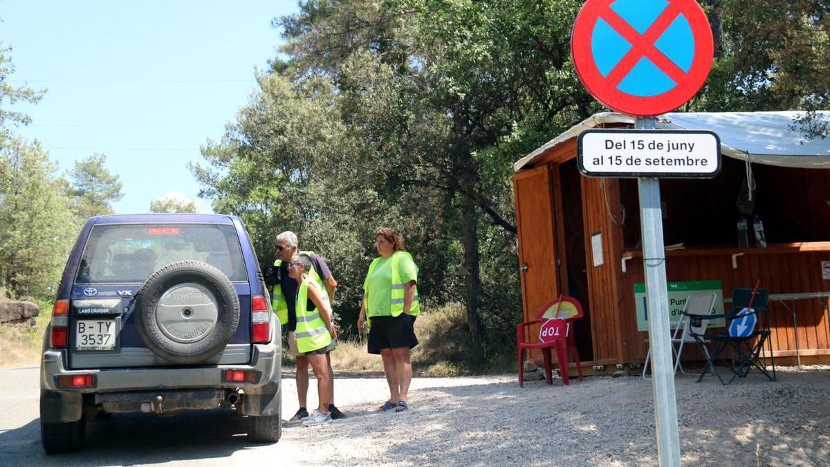 Els informadors avisen els conductors que està prohibit aparcar al llarg de tota la carretera que ressegueix la riera de Merlès