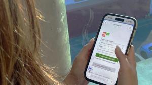 Una mujer con la aplicación La Meva Salut en su teléfono móvil.