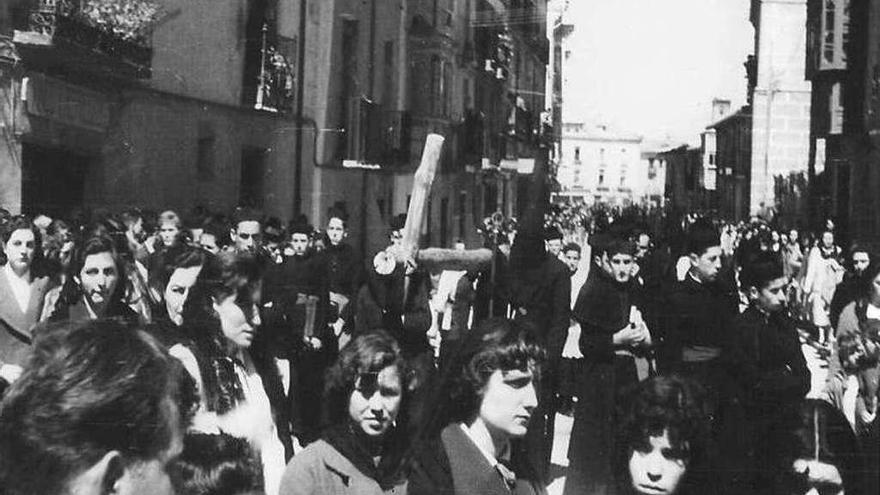 Hermanos de la cofradía portan la gran cruz realizada con postes de madera en la procesión de 1957.