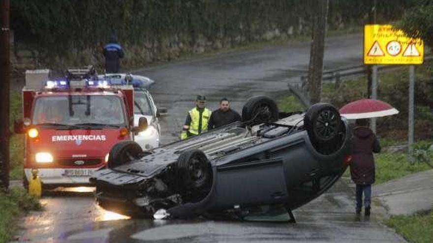 El coche volcado, atravesado en la carretera de Coiro. // Santos Álvarez