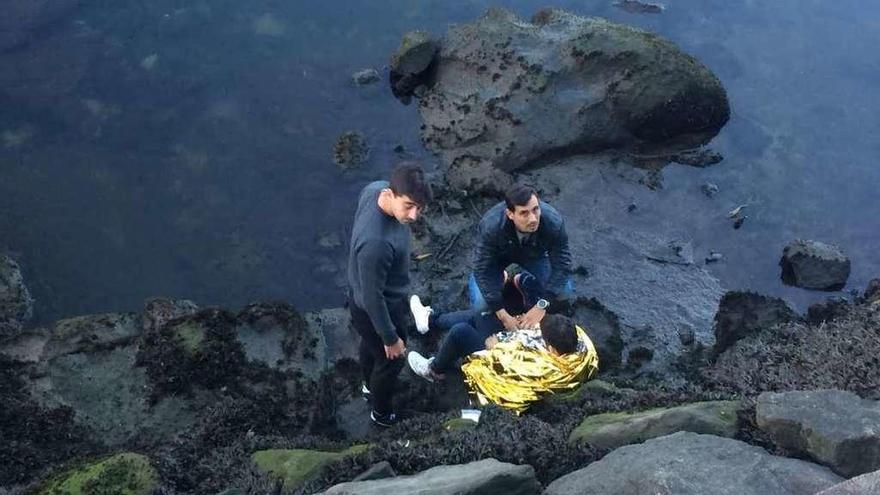 Dos personas atienden al herido, cubierto con una manta térmica. // FdV