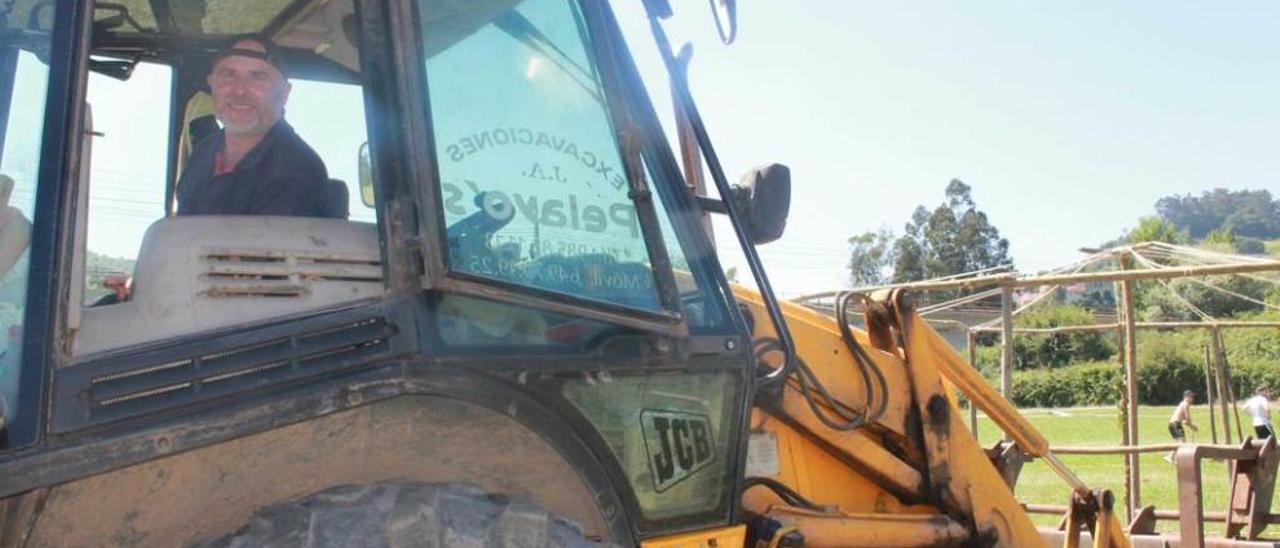 Pelayo Álvarez, en su pala excavadora, en el prao de Salceo (Pravia).