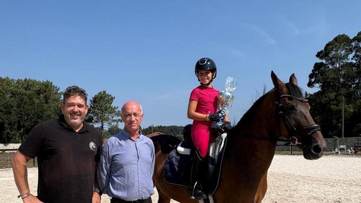 La joven amazona con el alcalde de Vilanova y su entrenador.