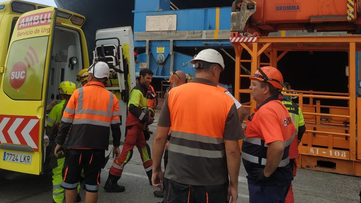 Los bomberos durante el rescate, esta tarde, del marinero accidentado.