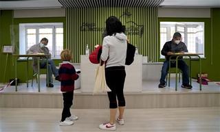 Una madre vota acompañada de su hijo, esta mañana en Madrid.