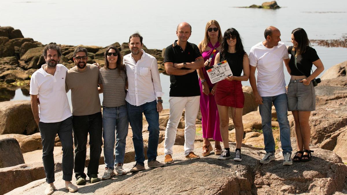 Jacobo Sutil, cuarto pola esquerda, e Nerea Barros, sétima, con edís de Ribeira e membros do equipo de rodaxe, este venres na praia de Castiñeiras.
