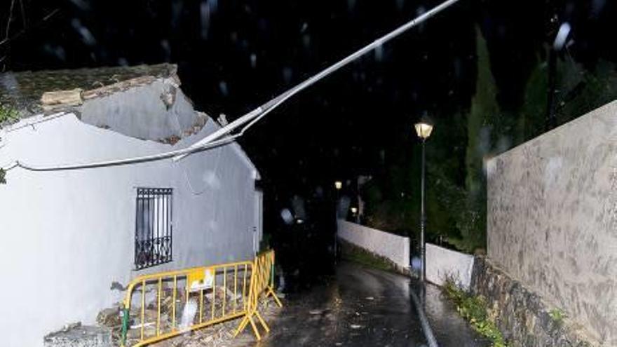 Poste y cable de luz derrumbados por el viento junto con parte del muro de una vivienda en Altea, a primera hora de anoche.