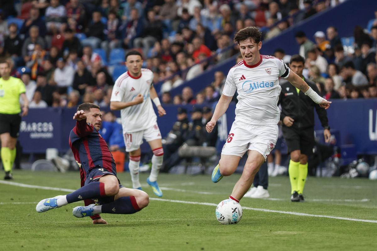 VALENCIA, 23/04/2026.- El centrocampista del Sevilla Joaquín Martínez "Oso" (d) pelea un balón con el defensa del Levante Adrián de la Fuente durante el partido de LaLiga de fútbol entre el levante y el Sevilla, este jueves en el estadio Ciutat de Valencia. EFE/ Manuel Bruque