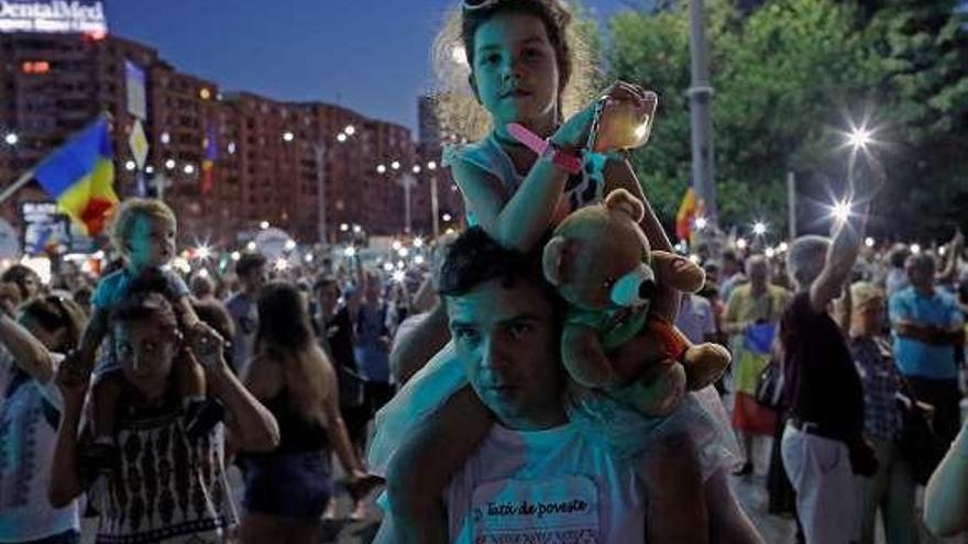 Un hombre con su hija, anoche, en la tercera jornada de protestas.