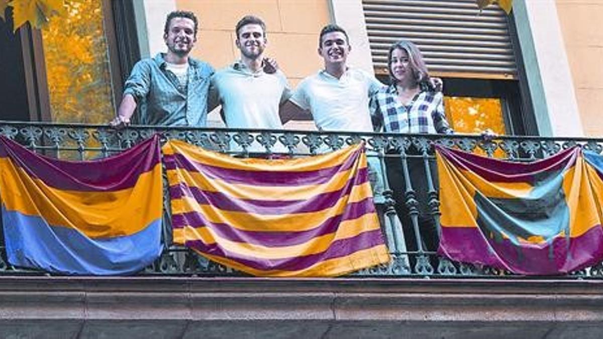 Adrià, Aitor, Marc y Amanda, con sus respectivas banderas en el balcón del piso que comparten en el número 49 de la calle de Sardenya.