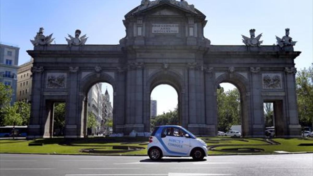 Un vehículo de Car2Go circula por la Puerta de Alcalá, en Madrid.