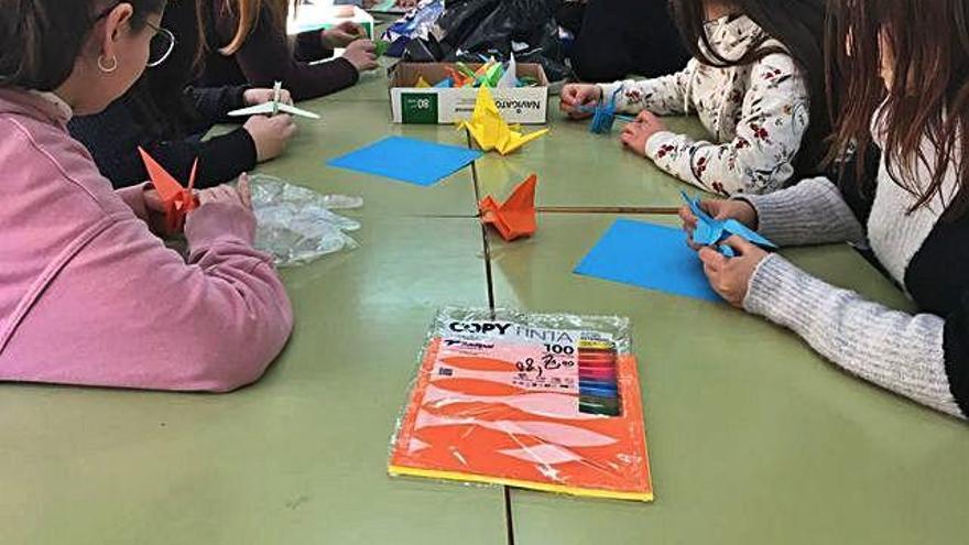 Los alumnos del instituto hacen grullas de papel.