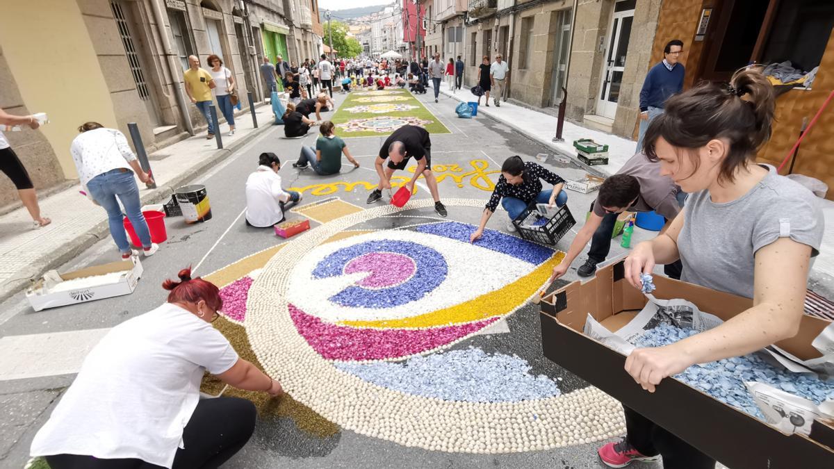 Vecinos trabajando en la elaboración de una alfombra en el barrio de Banda do Río.