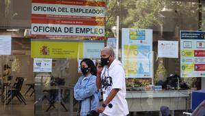 Imagen de archivo. Dos jóvenes pasan por delante de una oficina de empleo de Madrid.