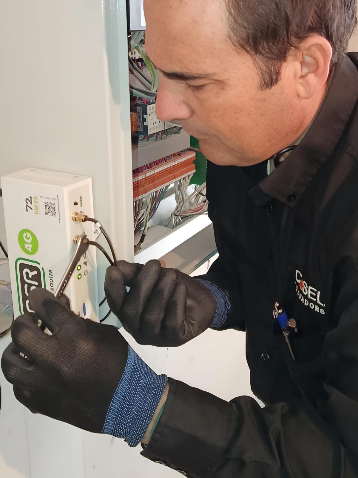 Técnico de Casel durante las labores de revisión y renovación de equipos de comunicación de emergencias de los ascensores, en Castellón.