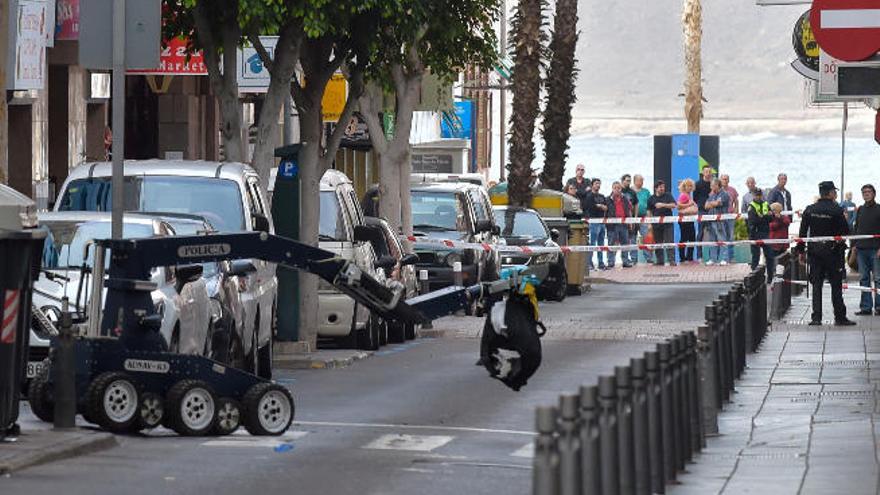 A la izquierda, el robot traslada la mochila sospechosa por la calle Bernardo de la Torre, ayer. A la derecha, los restos de la mochila tras las tres detonaciones en la calle Torres Quevedo.