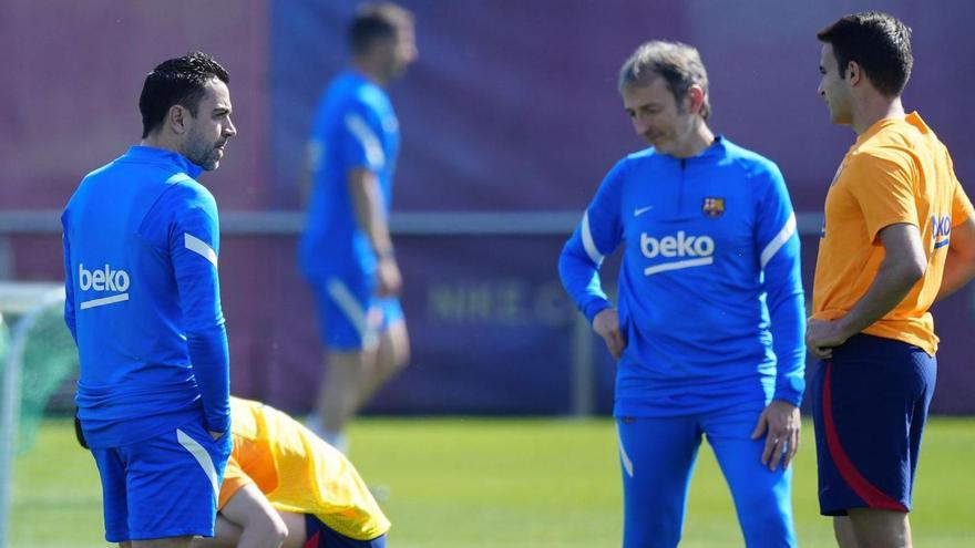 Xavi Hernández dialoga amb Èric Garcia en la sessió d’entrenament d’ahir. | EFE/ENRIC FONTCUBERTA