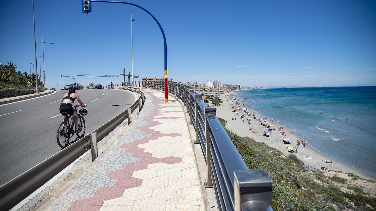 Una ciclista circula cerca de la Playa Galúa, en la Manga del Mar Menor