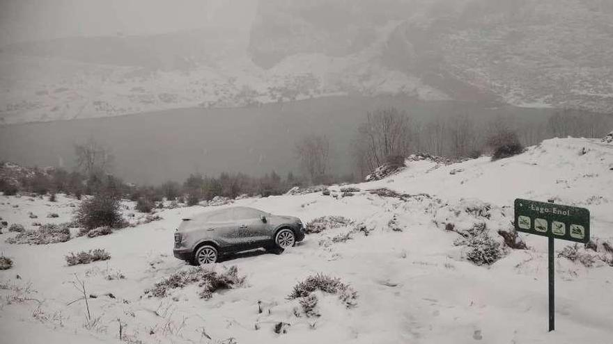 Un coche atrapado por la nieve en el lago Enol, ayer.