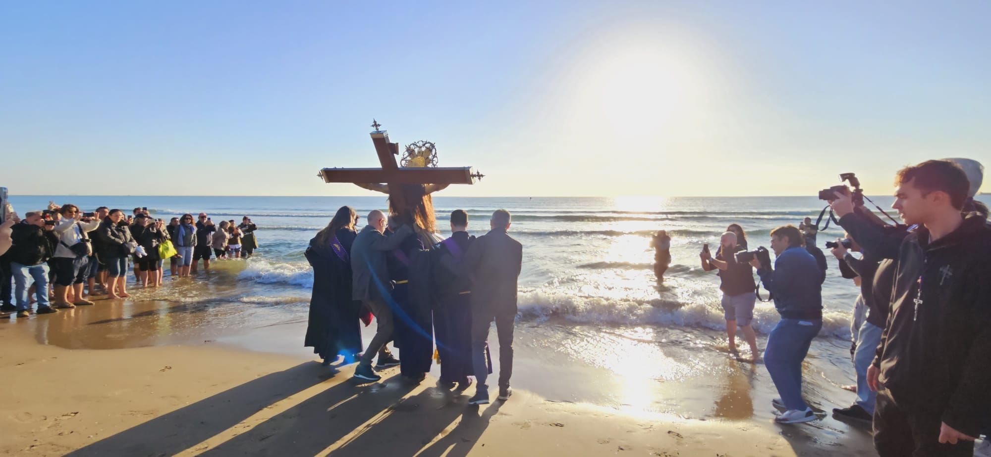 El Cristo del Salvador recuerda a los fallecidos en el mar a pie de playa después de su Encuentro con el Cristo del Salvador y el Amparo.