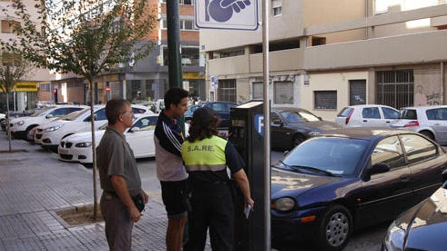 Una operaria del Sare explica el funcionamiento a dos ciudadanos.