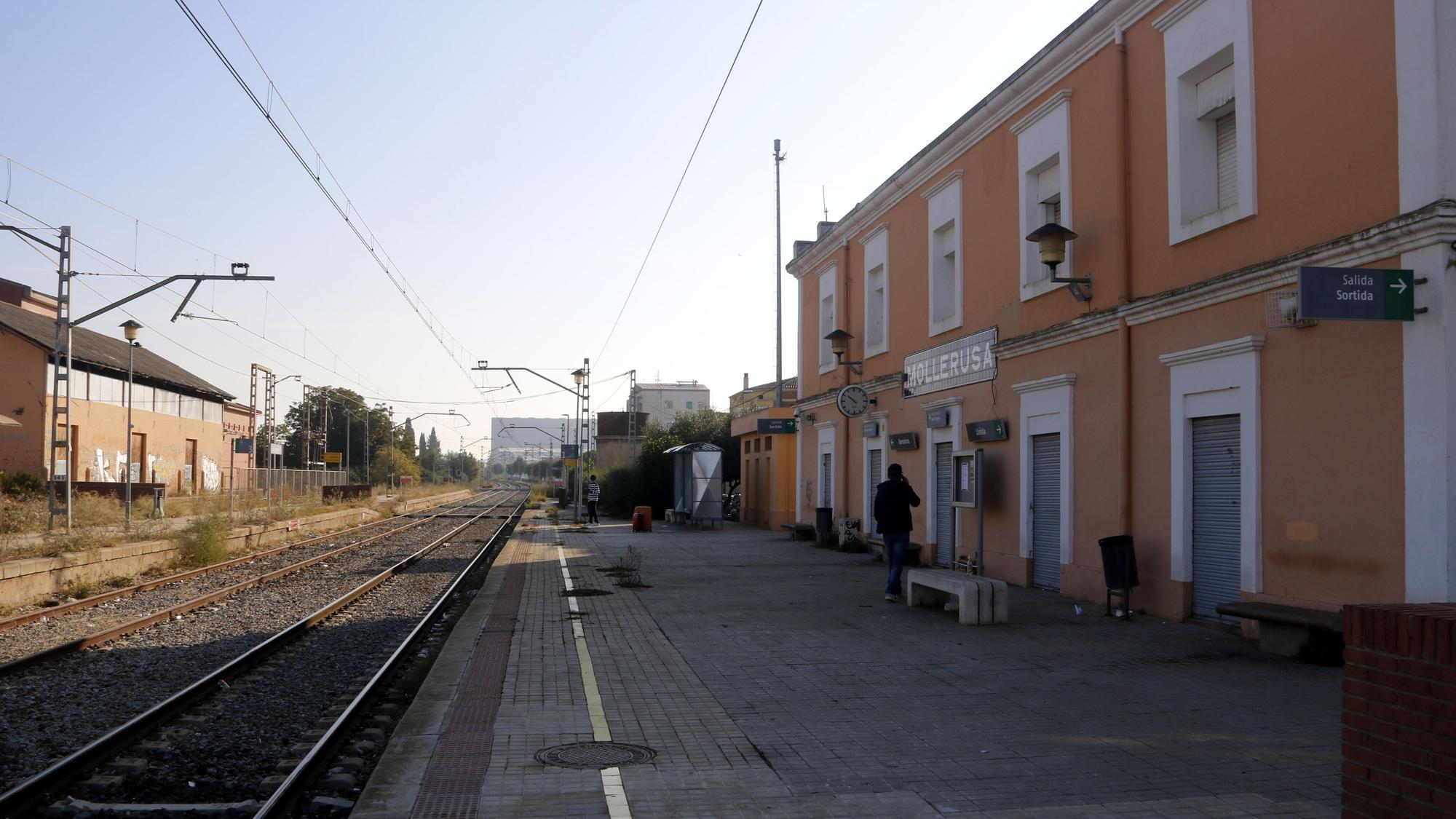 Pla general de l'estació de tren de Mollerussa, de la R12, amb dos persones esperant el tren, el 19 d'octubre de 2021. (Horitzontal)   foto: ORIOL BOSCH / ACN