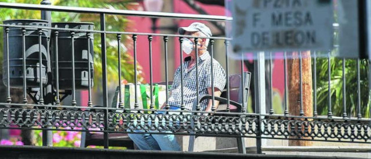 Un mayor descansa en una plaza de la capital grancanaria.