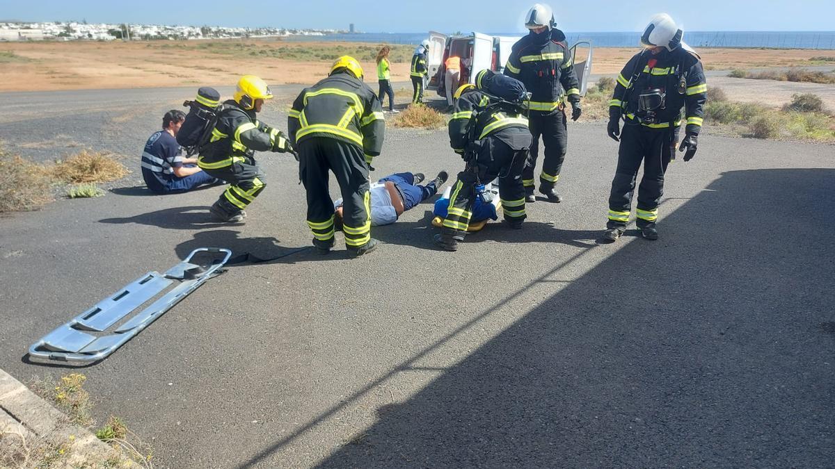 Bomberos del aeropuerto César Manrique Lanzarote atienden a uno de los supuestos heridos en el simulacro