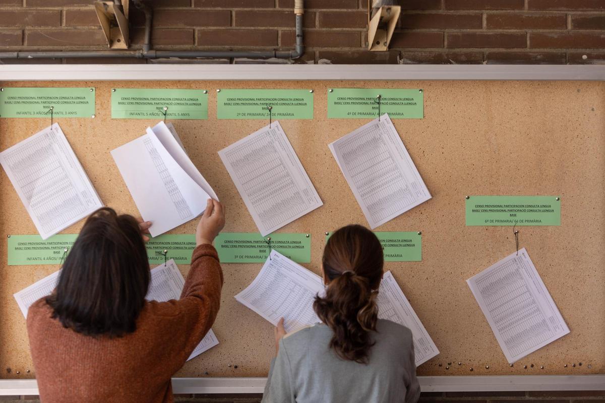 Padres consultando el censo para la consulta en un colegio de Alicante.