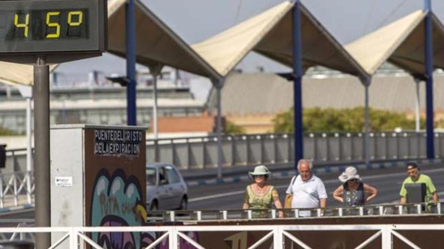 Unos turistas junto a un termómetro en el Puente del Cristo de la Expiración en Sevilla