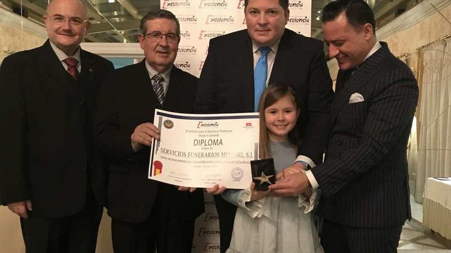 Javier Mendiri, en el centro, recibe el premio junto a su hija María.