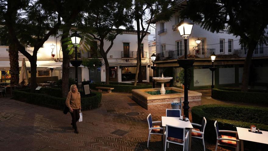 Una mujer pasea, al atardecer, por una solitaria plaza de las diversas que alberga el Casco Antiguo de Marbella.