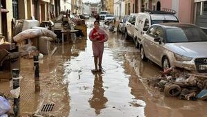 Una niña porta a su perro en una calle con múltiples daños de lAlcúdia.