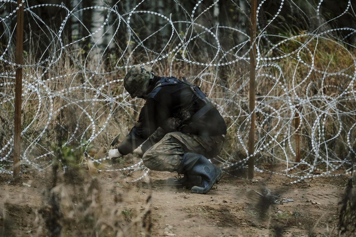 Soldados del ejército polaco arreglan bobinas de alambre de púas en una valla a lo largo de la frontera polaca, con el enclave ruso de Kaliningrado, cerca de Zerdziny, Polonia