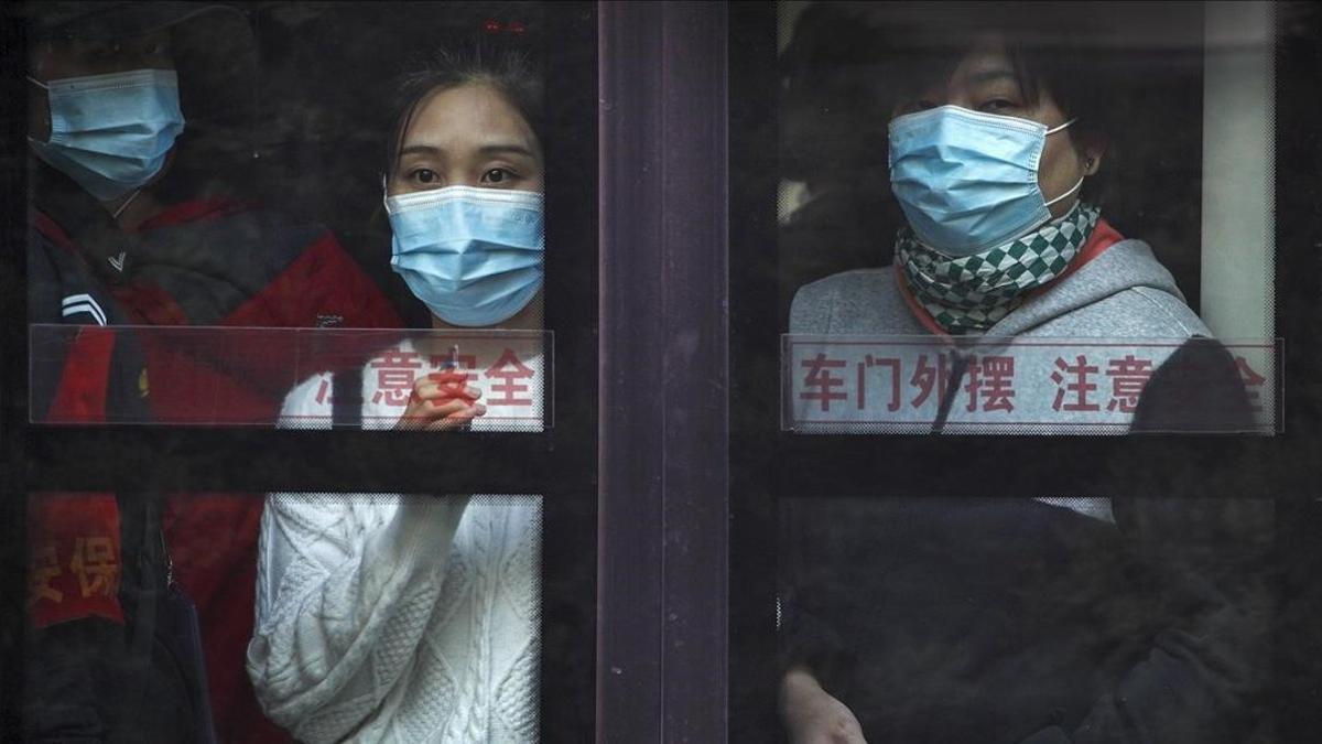 Dos personas en el transporte público usan mascarilla.