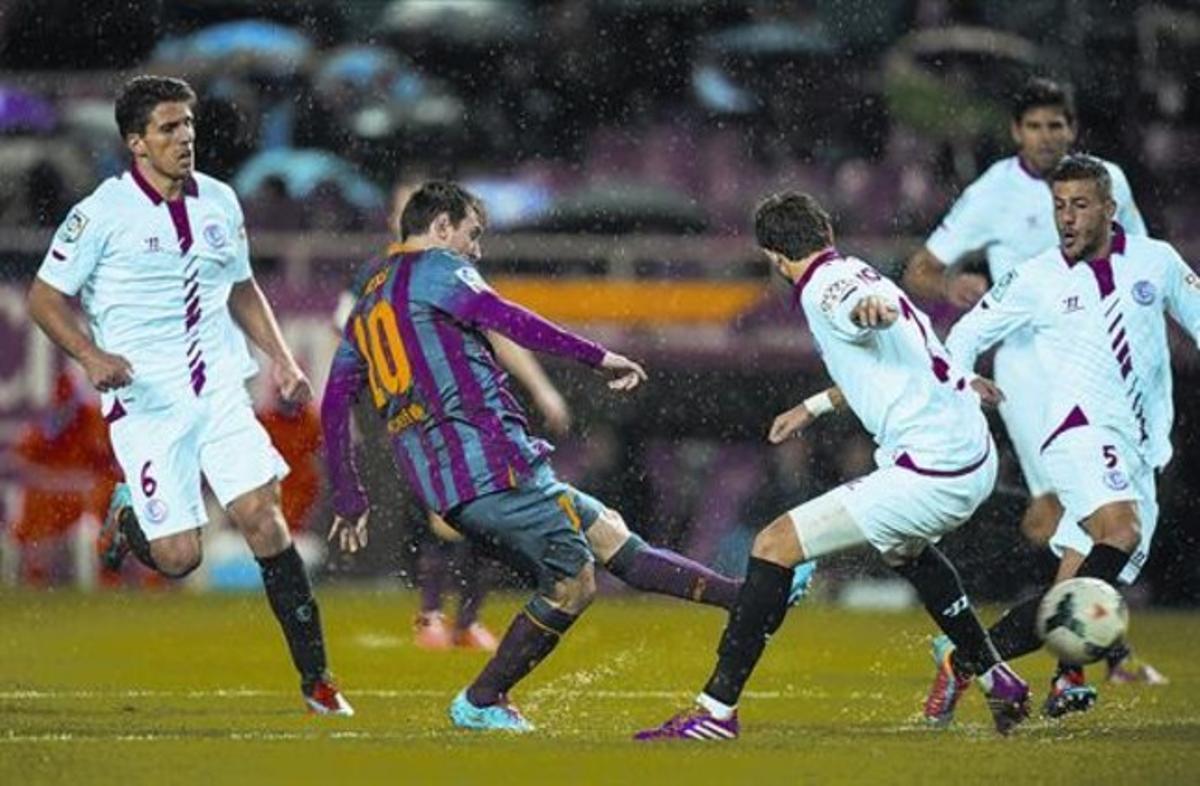 Messi dispara a porta en el seusegon gol envoltat de rivals, ahir.