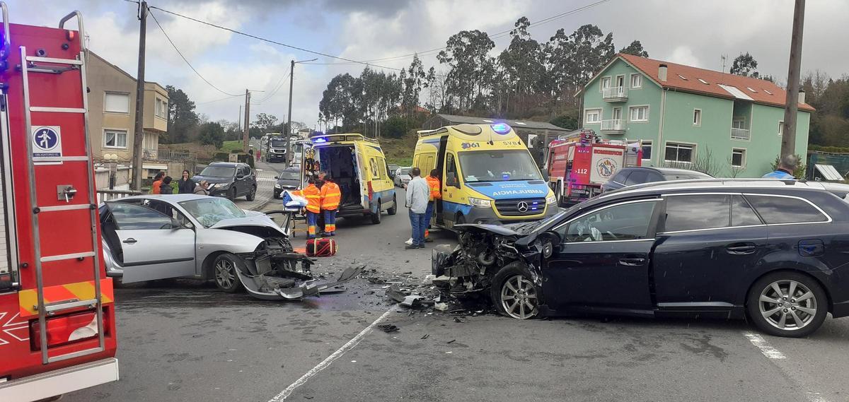 Sanitarios y bomberos atendiendo a las dos conductoras heridas.