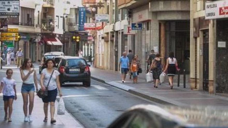 Vecinos y turistas pasan estos días por calles con el comercio cerrado por vacaciones