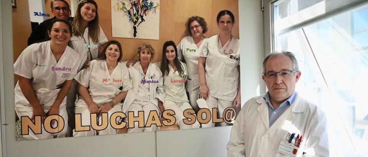 Francisco Ramón García Arroyo posa junto a un póster motivacional en la sala de tratamiento de Oncología.