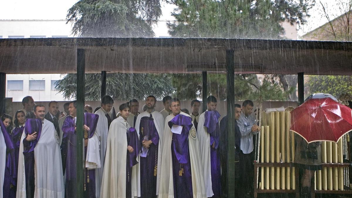 Unos nazarenos se protegen en Sevilla de la fuerte lluvia caída un día de Jueves Santo, en una imagen de archivo.