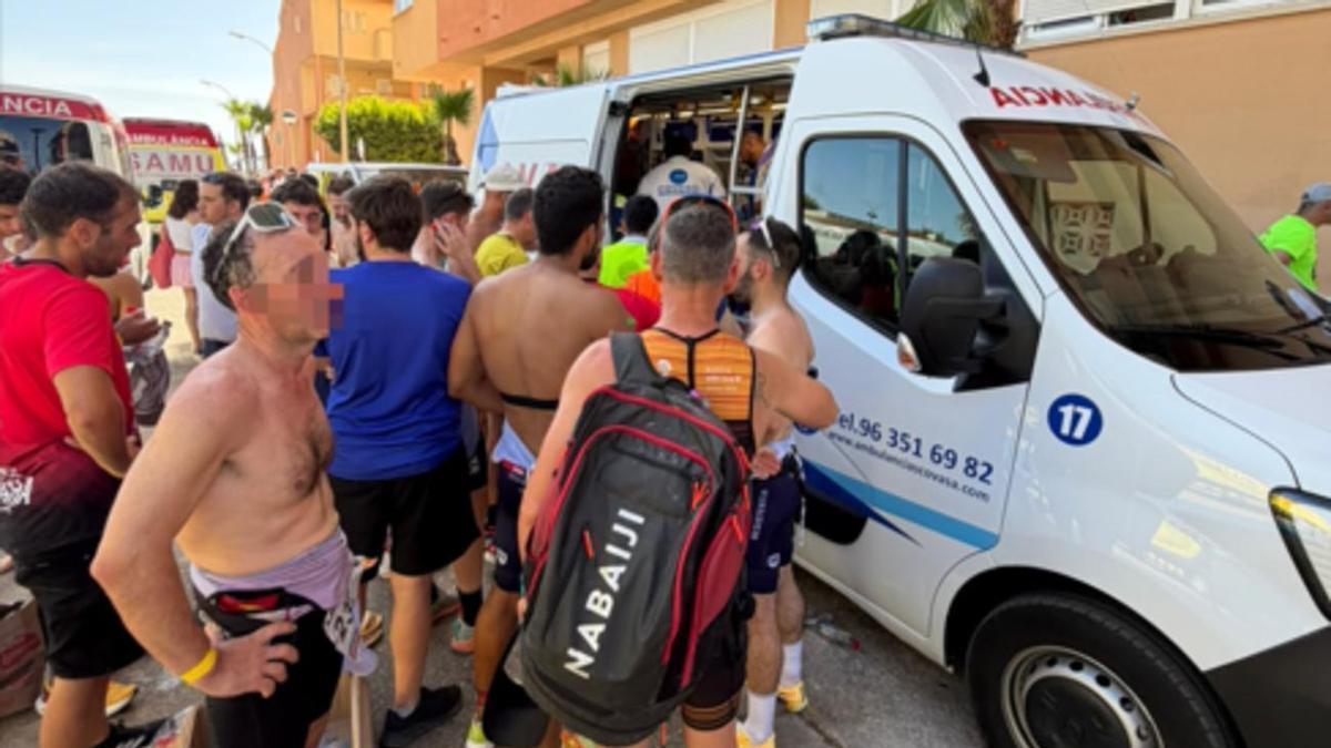 Participantes acuden a una ambulancia para ser atentidos tras sufrir picaduras de medusas en el Triatlón de Tavernes de la Valldigna