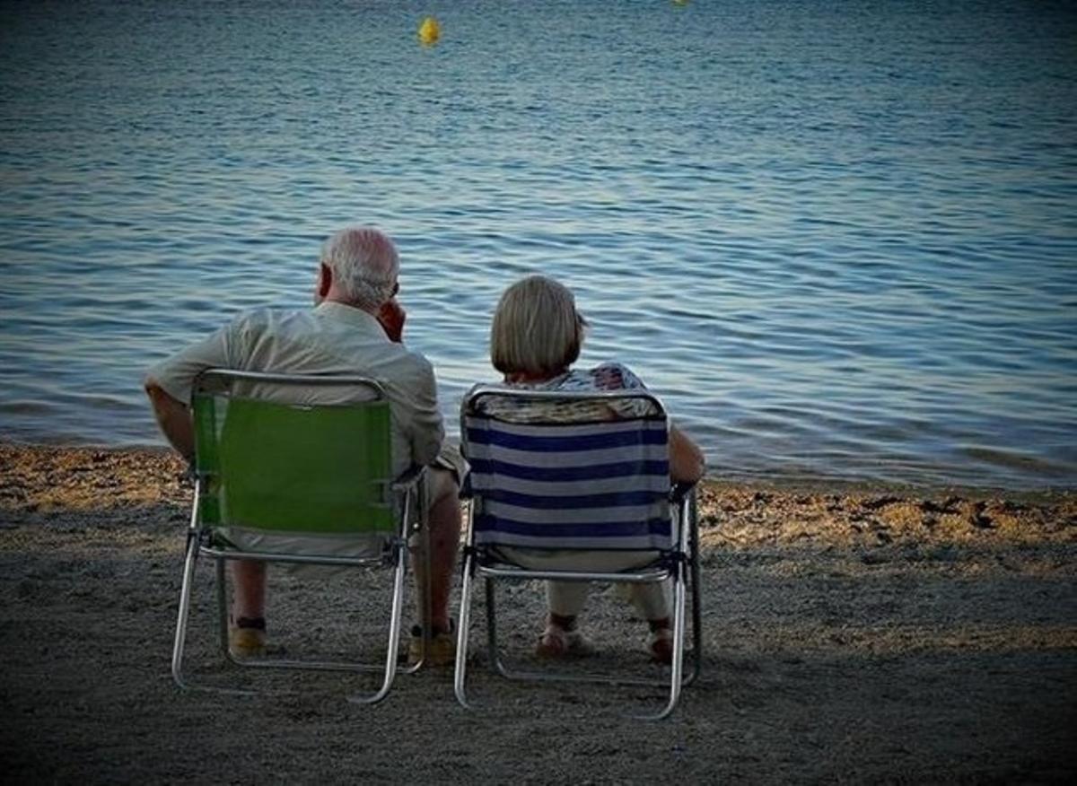 Una pareja de jubilados descansa en la playa