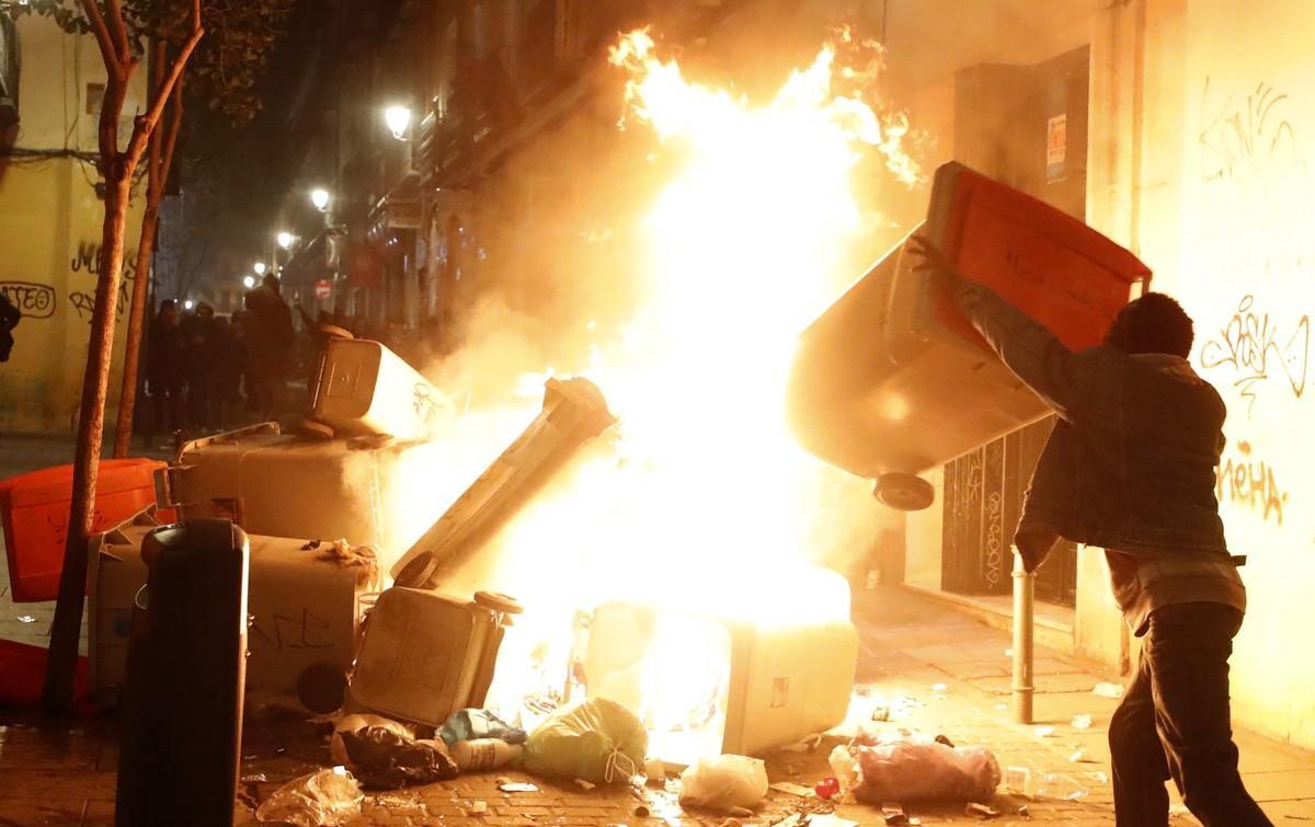 GRAF3267  MADRID  15 03 2018 - Contenedores incendiados en la calle Meson de Paredes con la calle del Oso  en el barrio de Lavapies de Madrid  tras la muerte de un mantero de un paro cardiaco durante un control policial contra el top manta en el barrio de Lavapies de Madrid  Tras el suceso  se han concentrado decenas de personas en protesta contra la presion policial que existe en la zona contra los vendedores del top manta  EFE JAVIER LIZON